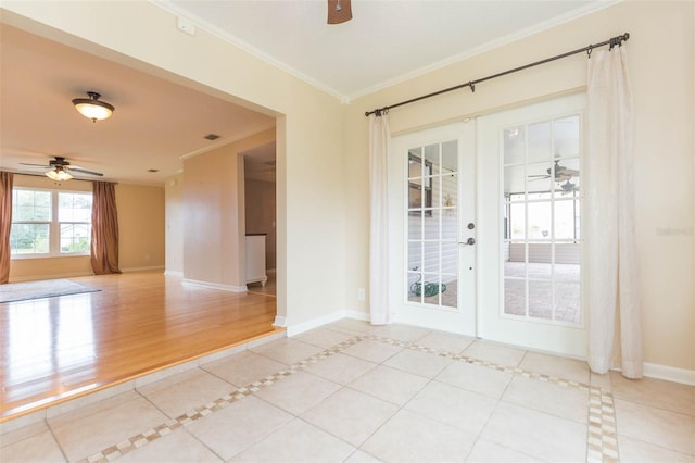 empty room featuring french doors, light tile patterned floors, ceiling fan, and ornamental molding