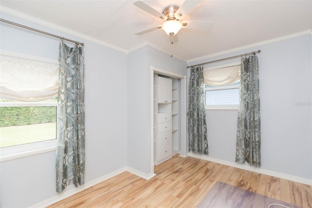 empty room featuring a textured ceiling, light wood-type flooring, ceiling fan, and ornamental molding