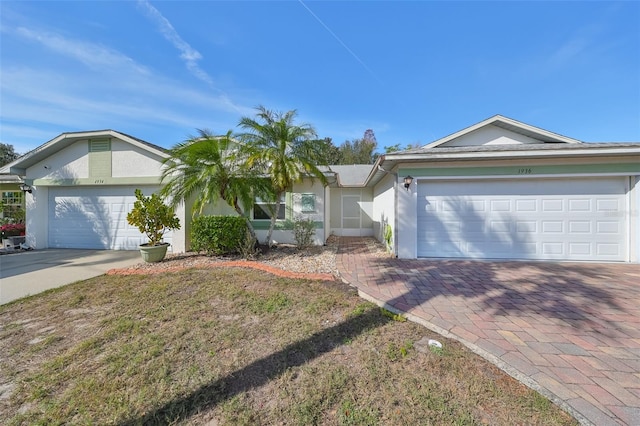 ranch-style house with a garage and a front lawn