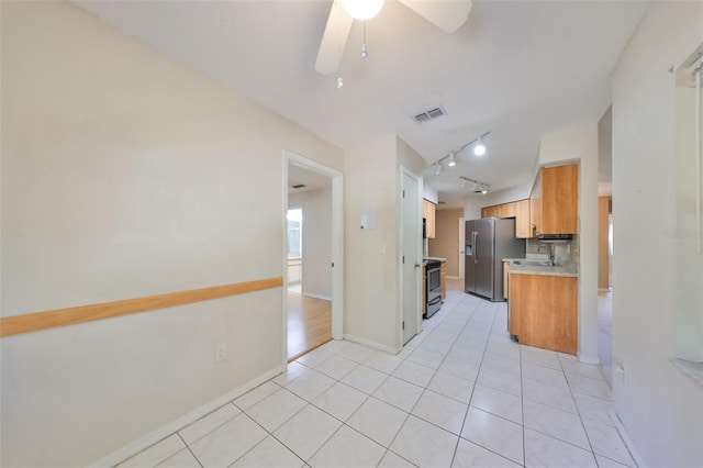 kitchen with ceiling fan, rail lighting, black electric range oven, stainless steel fridge, and light tile patterned floors