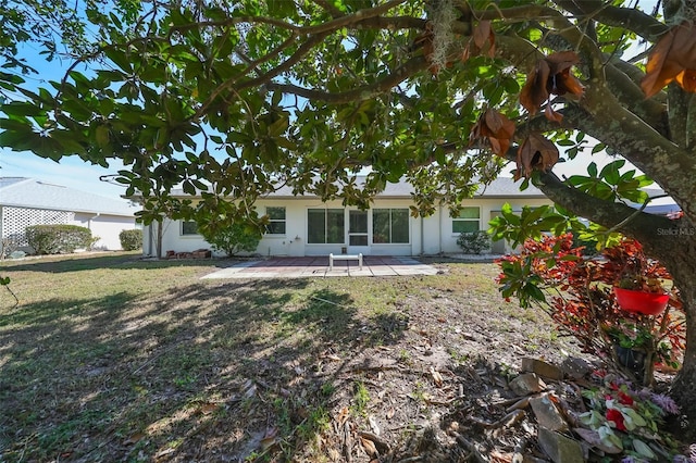 rear view of property featuring a lawn and a patio area