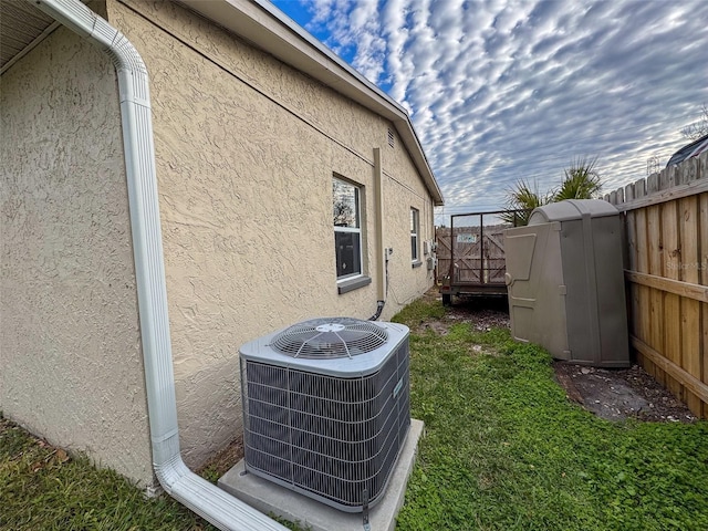 view of side of home featuring a yard and cooling unit