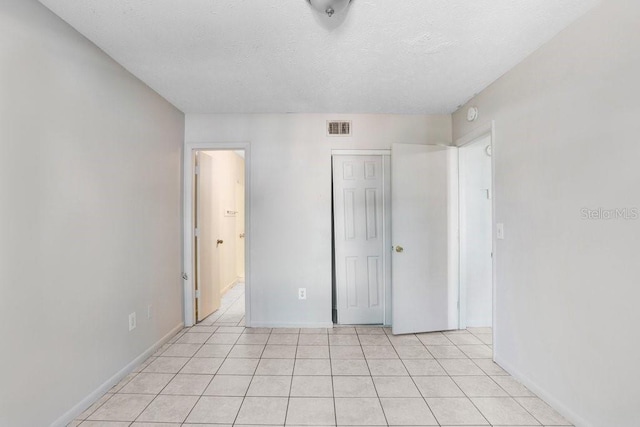 unfurnished bedroom featuring light tile patterned floors and a textured ceiling