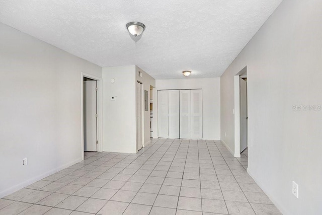 tiled empty room with a textured ceiling