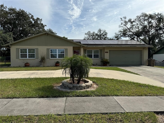 ranch-style house with a front lawn, a garage, and solar panels