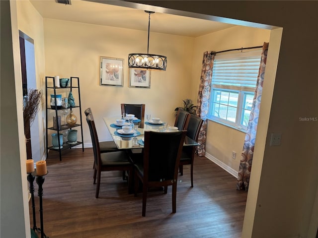 dining area with dark hardwood / wood-style flooring and a chandelier