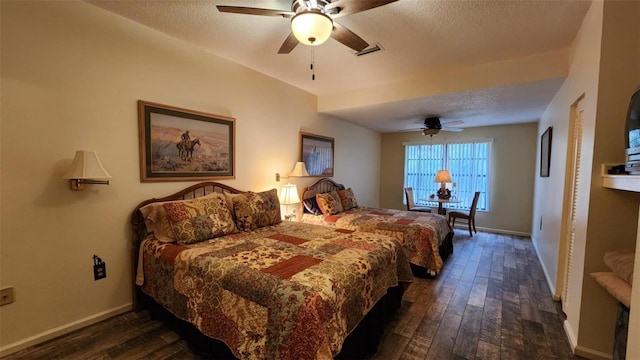 bedroom with ceiling fan, dark wood-type flooring, and a textured ceiling