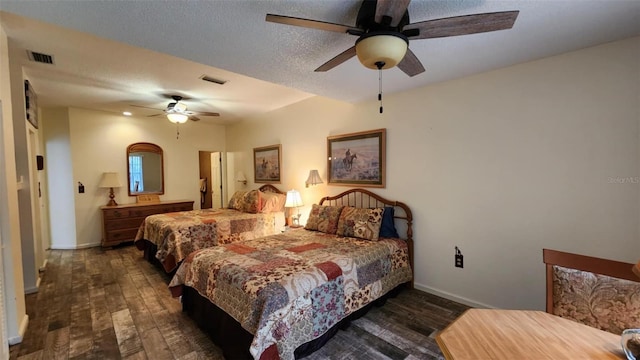 bedroom with ceiling fan, dark hardwood / wood-style floors, and a textured ceiling