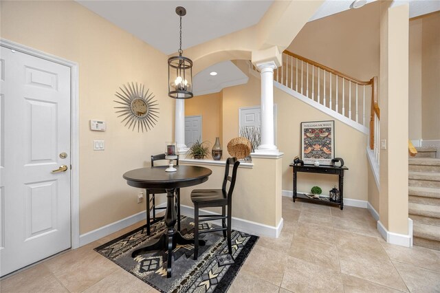 tiled foyer entrance featuring ornate columns and a chandelier