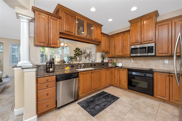 kitchen featuring sink, stainless steel appliances, decorative columns, dark stone countertops, and light tile patterned floors