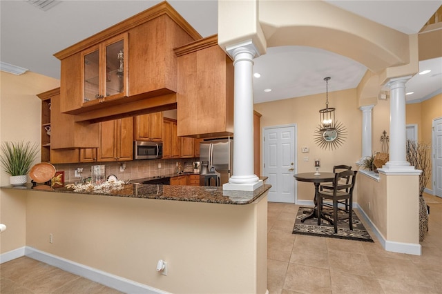 kitchen featuring decorative light fixtures, dark stone countertops, kitchen peninsula, and appliances with stainless steel finishes