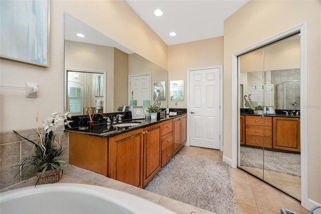 bathroom with plus walk in shower, tile patterned flooring, and vanity