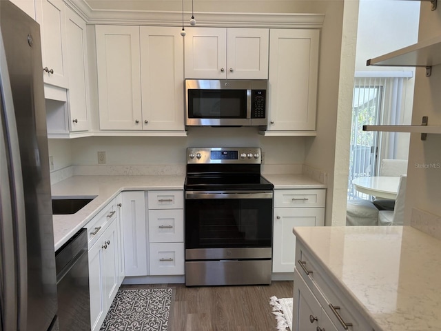 kitchen with white cabinets, sink, light stone countertops, dark hardwood / wood-style flooring, and stainless steel appliances