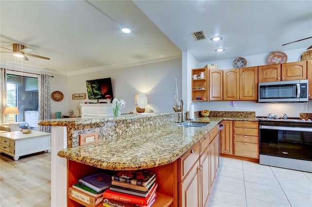 kitchen featuring kitchen peninsula, appliances with stainless steel finishes, light stone countertops, ornamental molding, and sink