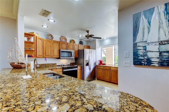 kitchen featuring sink, ceiling fan, appliances with stainless steel finishes, light stone counters, and kitchen peninsula