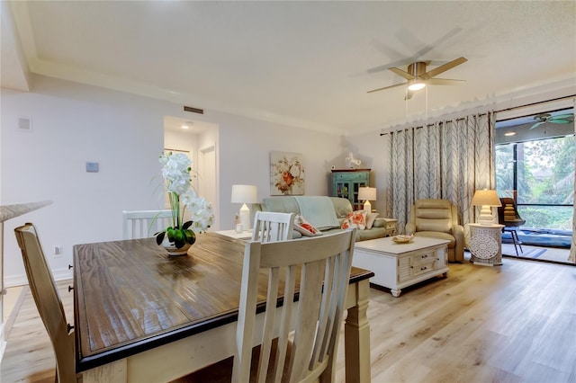 dining area featuring light hardwood / wood-style floors and crown molding