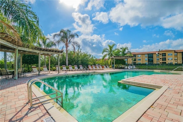 pool with a patio area, fence, and a pergola