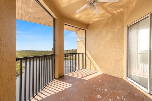 balcony with a ceiling fan and a water view