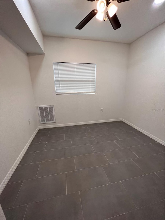 tiled spare room featuring ceiling fan