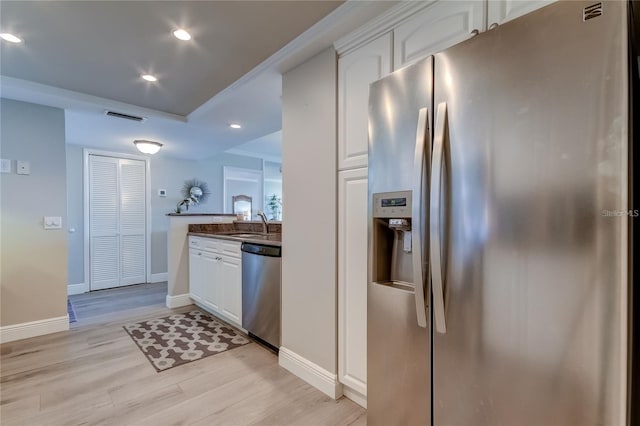 kitchen featuring stainless steel appliances, white cabinetry, sink, and light hardwood / wood-style flooring