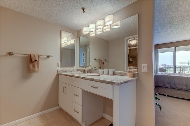 bathroom with tile patterned floors, vanity, and a textured ceiling