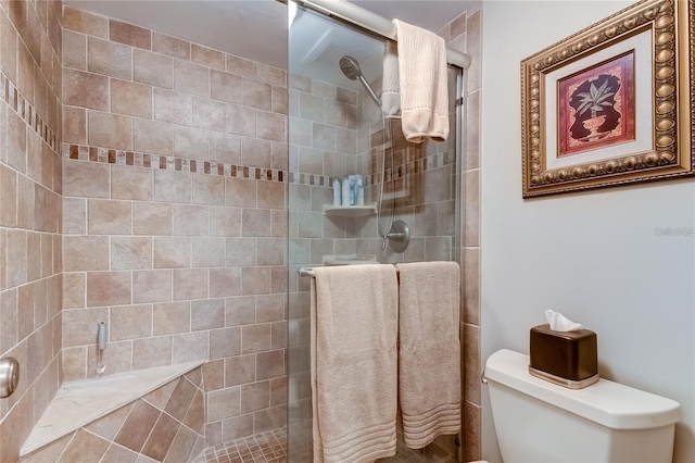 bathroom featuring toilet and a shower with shower door