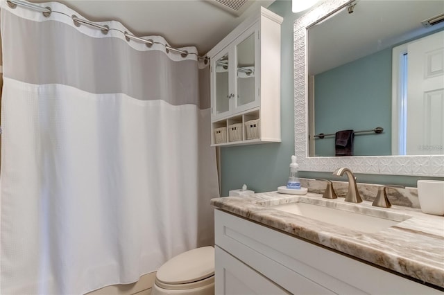 bathroom with vanity, curtained shower, and toilet