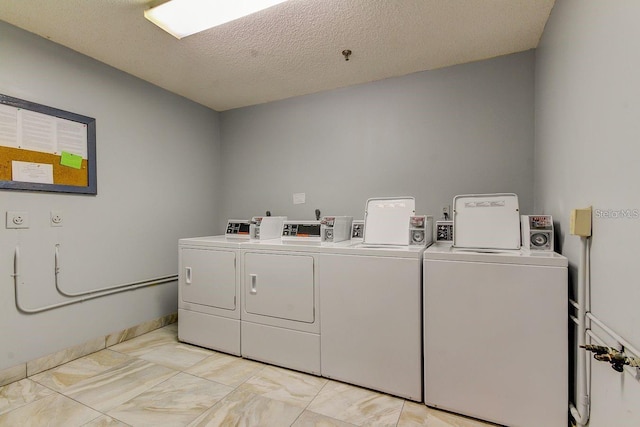 washroom with washing machine and clothes dryer and a textured ceiling