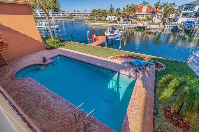 view of pool featuring a dock, a water view, and a patio