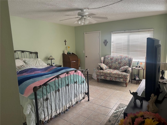 tiled bedroom with ceiling fan and a textured ceiling