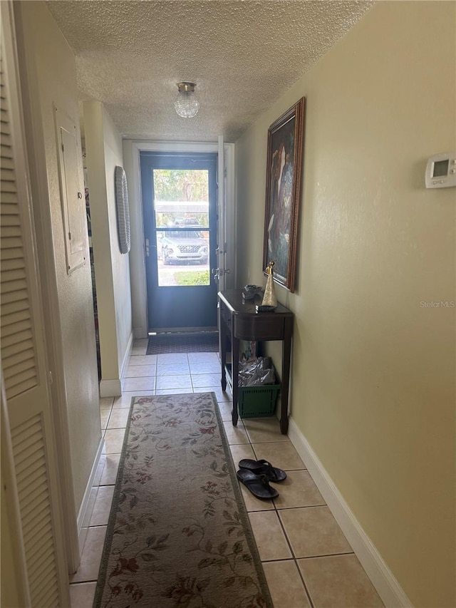 entryway with light tile patterned flooring and a textured ceiling