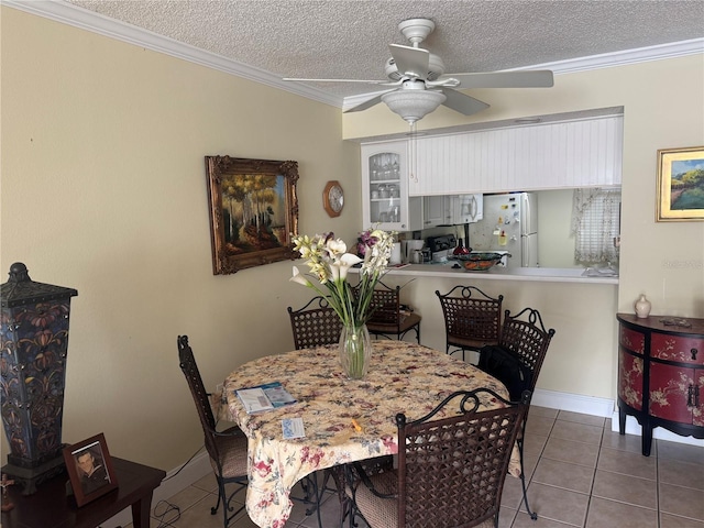 dining space with tile patterned flooring, ceiling fan, crown molding, and a textured ceiling