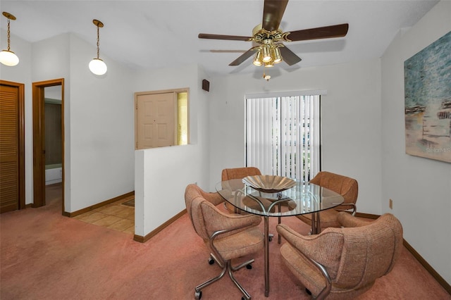 dining room with ceiling fan and light carpet