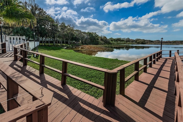 dock area with a lawn and a water view