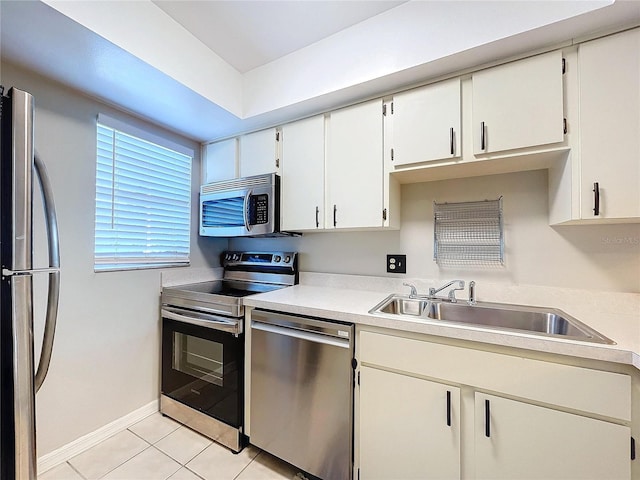 kitchen with white cabinets, sink, light tile patterned flooring, and appliances with stainless steel finishes