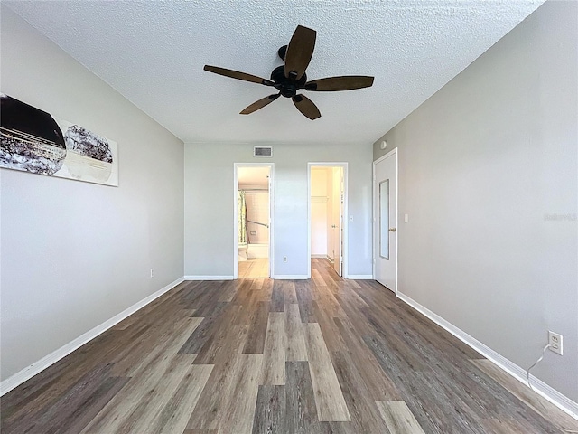 unfurnished bedroom featuring ceiling fan, wood-type flooring, a textured ceiling, and ensuite bath