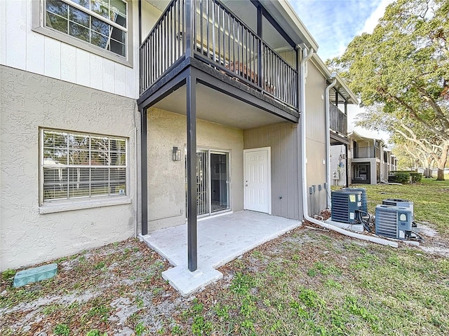 rear view of house featuring a patio area, a balcony, and central air condition unit