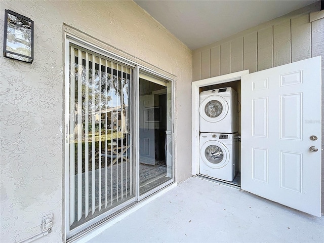 view of exterior entry with stacked washer and dryer