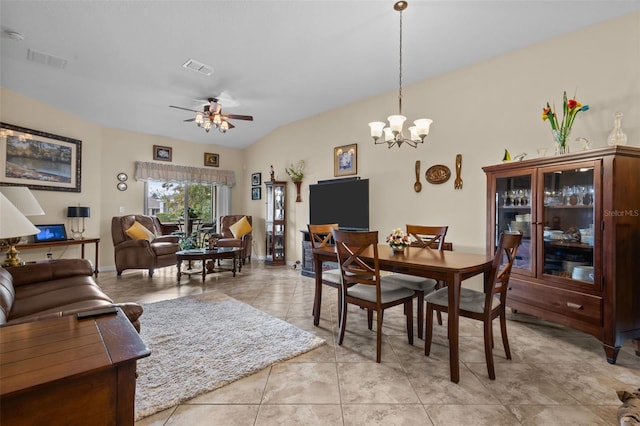 tiled dining space featuring ceiling fan with notable chandelier and lofted ceiling