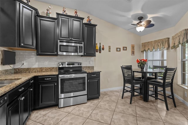 kitchen with decorative backsplash, ceiling fan, light stone countertops, light tile patterned floors, and stainless steel appliances