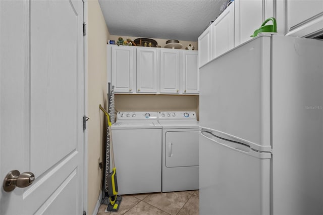 washroom with washer and clothes dryer, light tile patterned flooring, and a textured ceiling