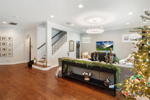 living room featuring a chandelier, dark hardwood / wood-style flooring, and ornamental molding