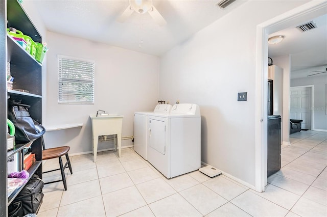 washroom with light tile patterned floors, washing machine and dryer, ceiling fan, and sink