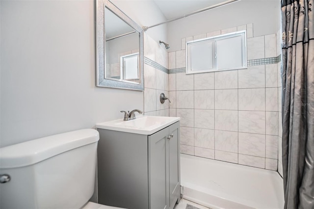 bathroom featuring vanity, toilet, and walk in shower