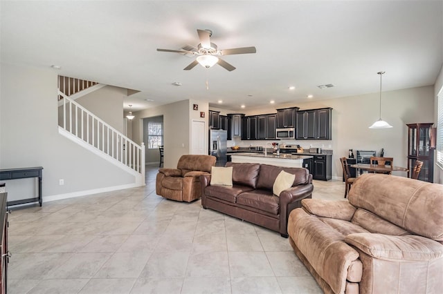 tiled living room featuring ceiling fan and sink