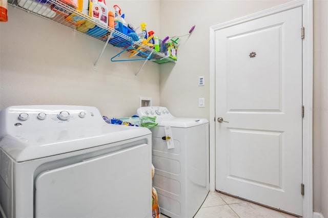 laundry area featuring light tile patterned floors and separate washer and dryer