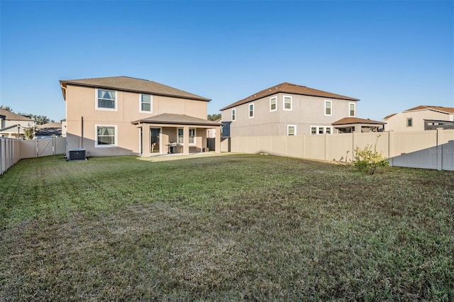 back of house with a yard, a patio, and central AC