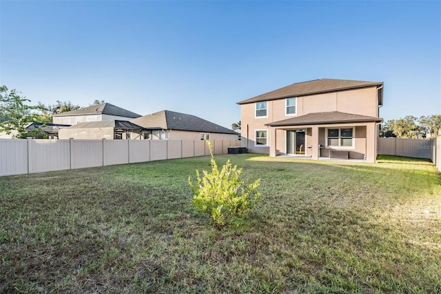 back of property with a yard and central AC unit