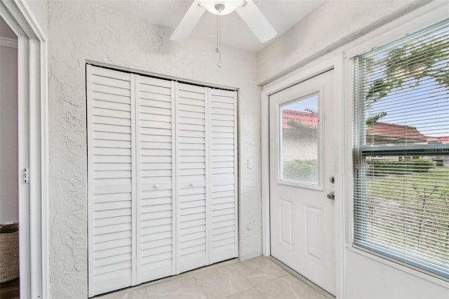 entryway featuring ceiling fan and light tile patterned flooring