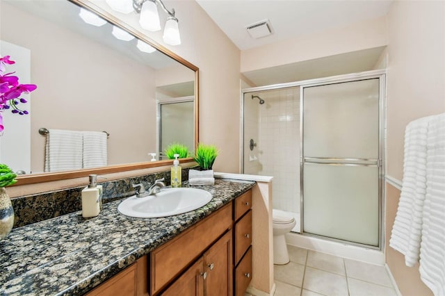 bathroom featuring vanity, toilet, tile patterned floors, and a shower with door